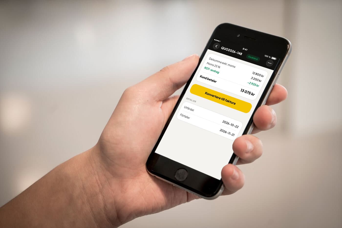 En hand håller en mobil som visar en godkänd offert i Tradesnap